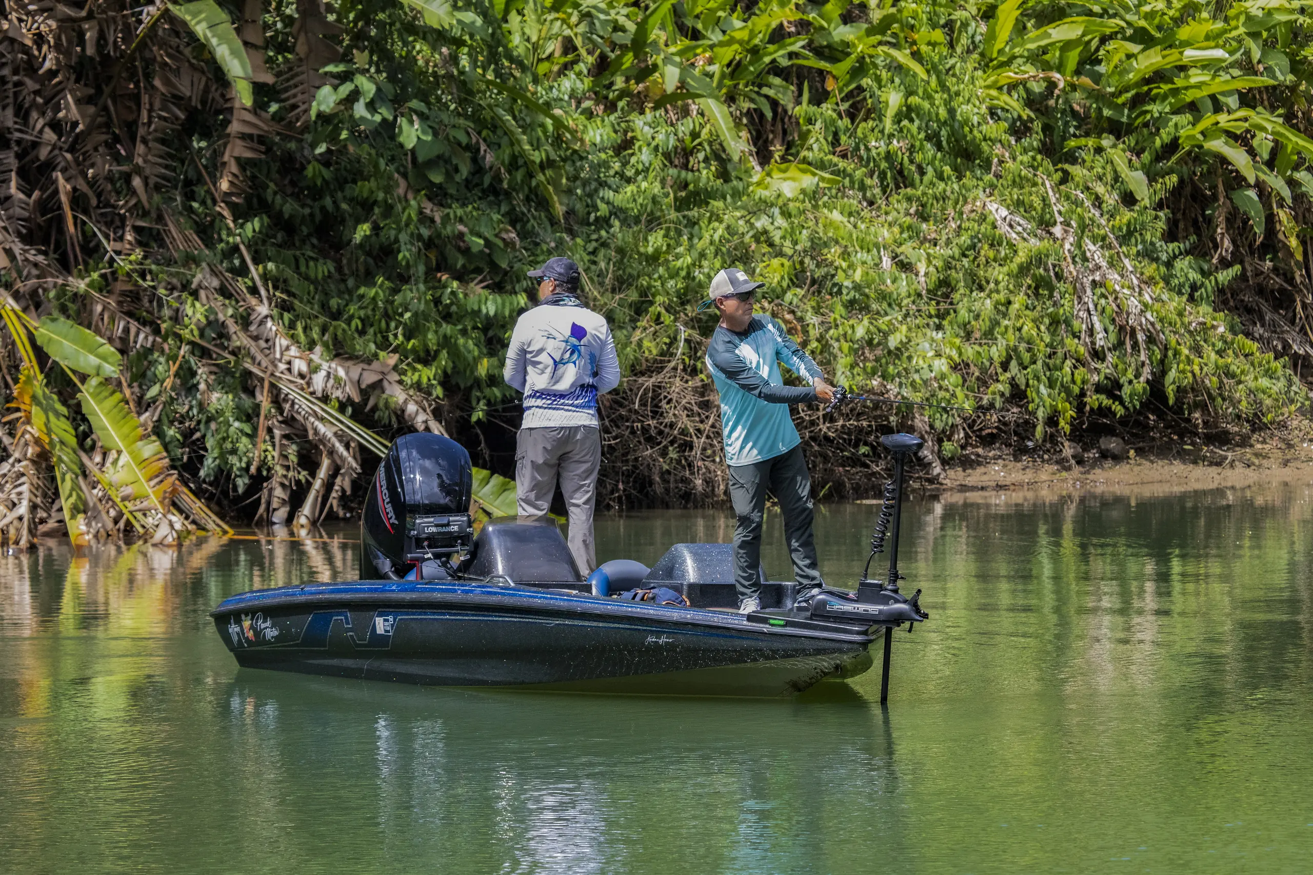 Peacock bass fishing boat along the forested shore of Gatún Lake, Panama