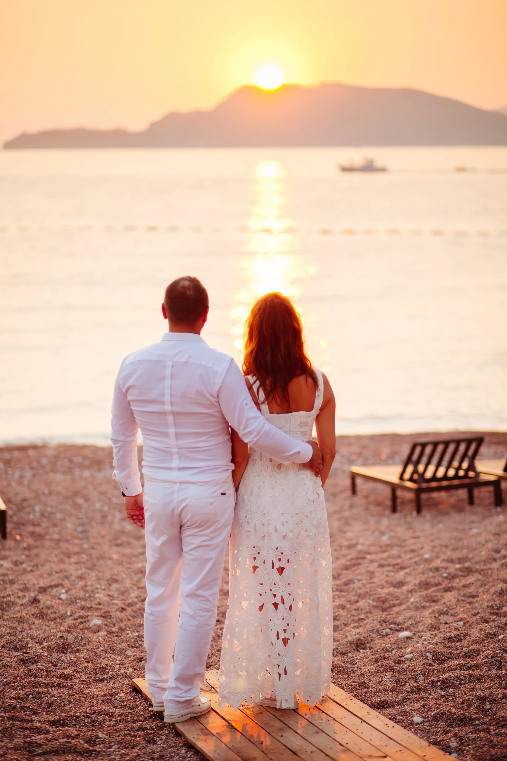 Una pareja en la playa al atardecer